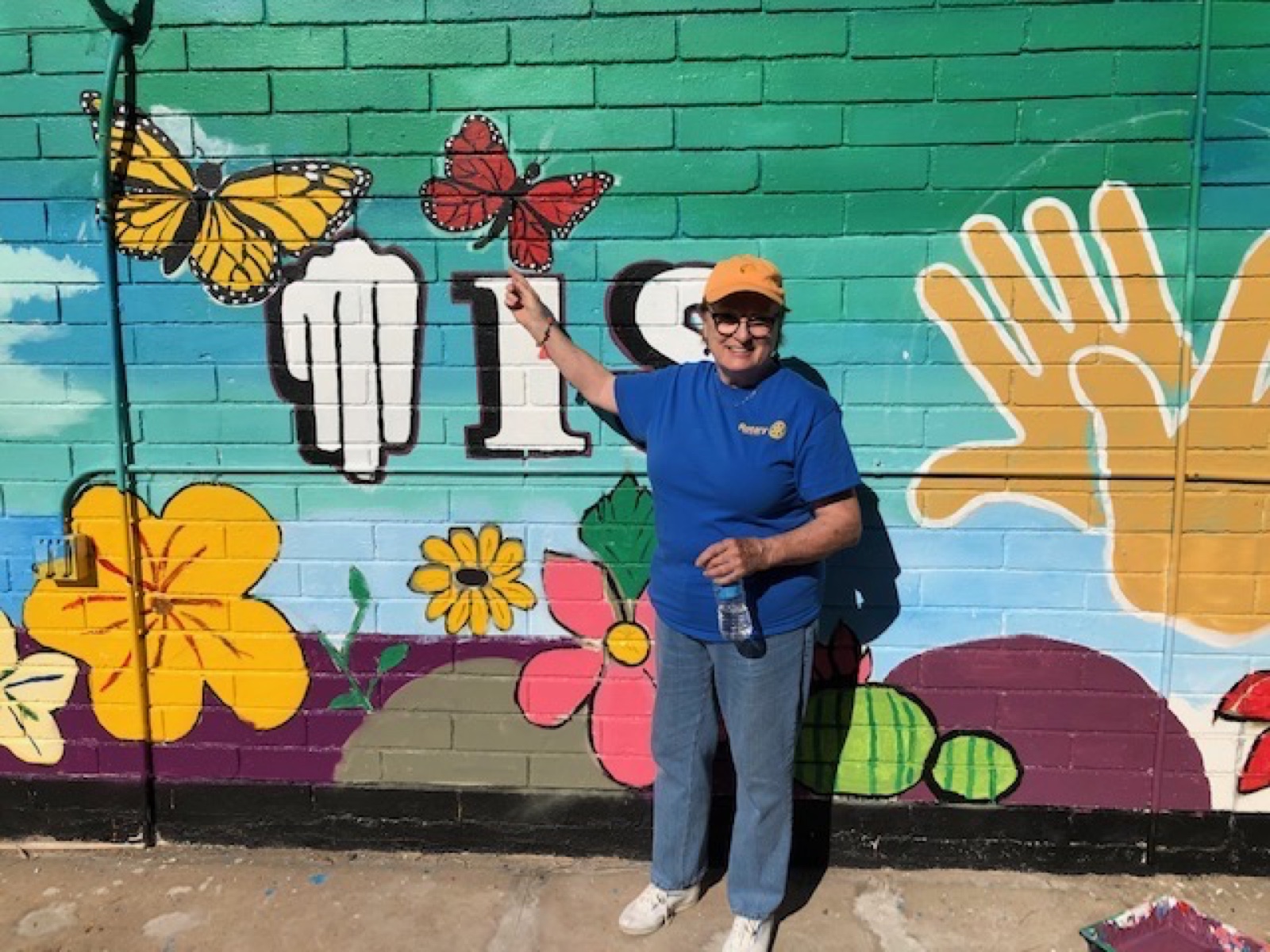 A Palm Desert Rotarian beside a freshly painted community mural in Mexicali
