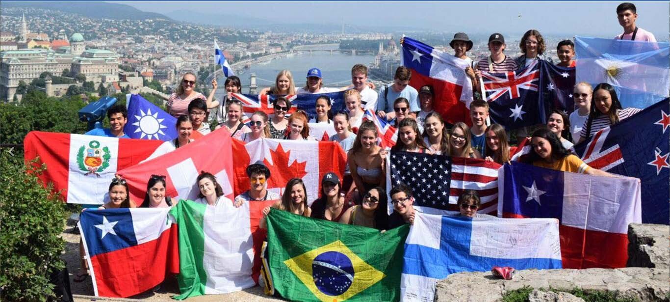 District 5330 Rotary Youth Exchange students holding flags from their home countries