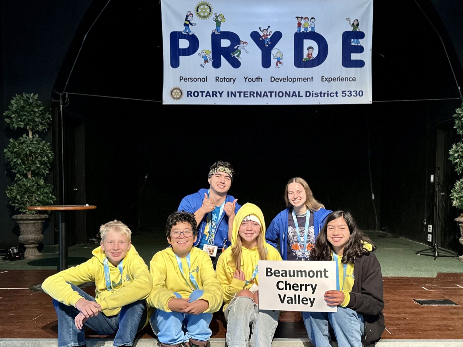 A sponsoring club's students at PRYDE 2023, under the PRYDE banner