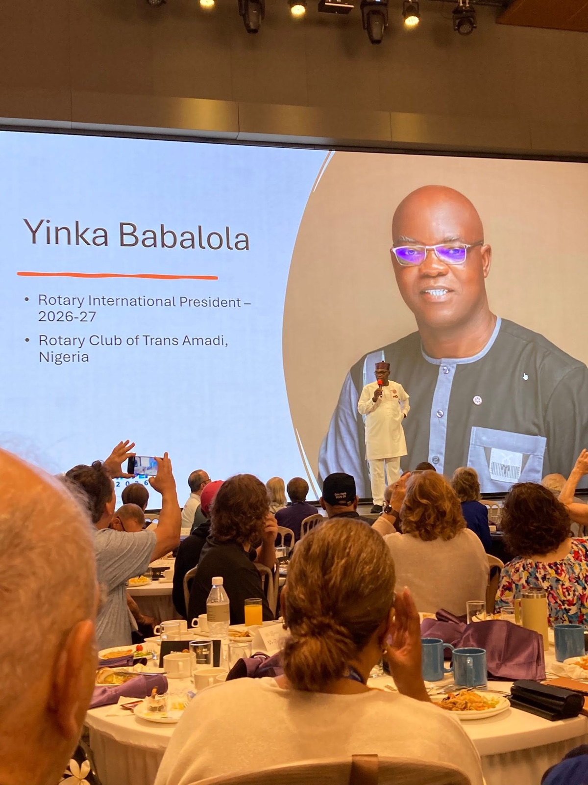 RI President-Elect Yinka Babalola on screen during a general session